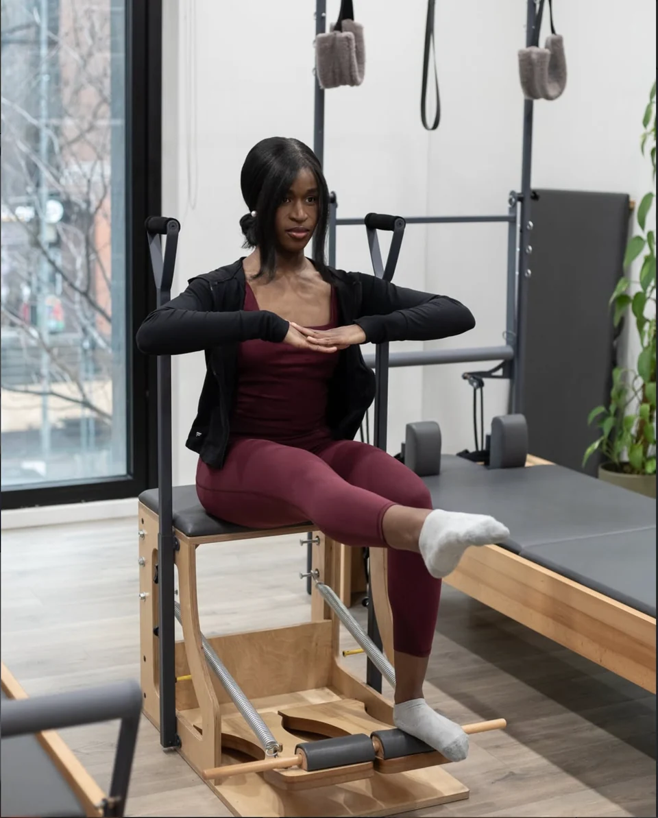 Një pjesëmarrëse duke ushtruar ekuilibrin në karrigen Pilates